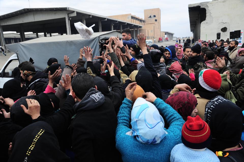  desperate refugees have been forced to scramble for food parcels in recent days as they are evacuated from Aleppo