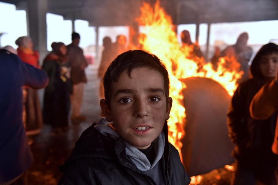  Young children are amongst those huddling for warmth around fires in the Syrian city