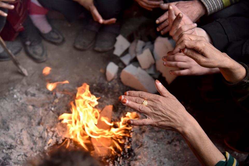  Displaced Syrians have been forced to build a fire to keep warm at the Jibreen temporary shelter, south of Aleppo