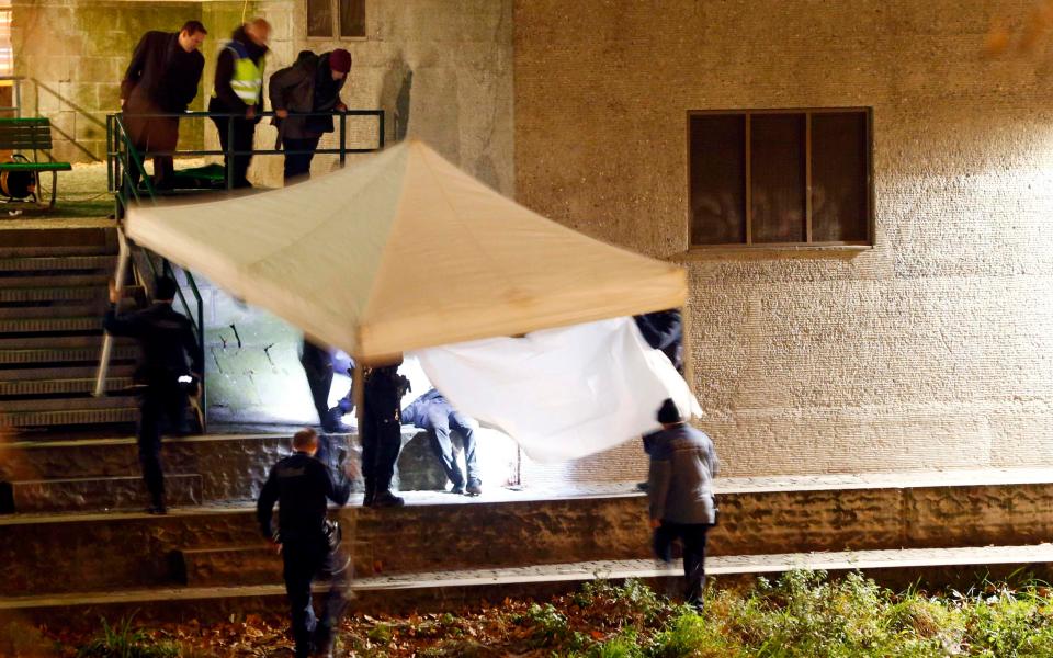  The body of the mystery shooter is covered up by police after he was found near the river not far from the mosque