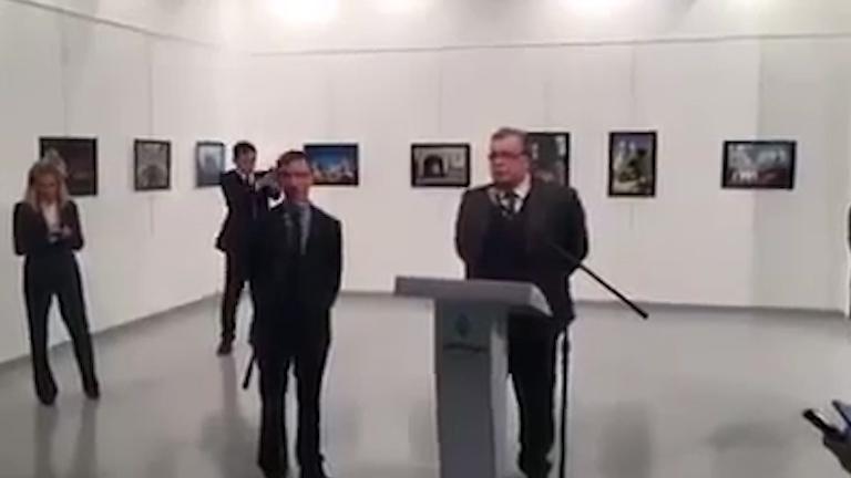  Gunman Mevlut Mert Altinas pictured standing behind the Russian ambassador Andrei Karlov just before killing him