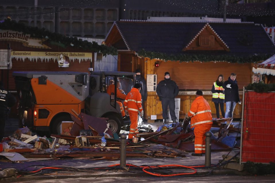  Workers start the grim task of clearing crushed stalls at the Berlin market