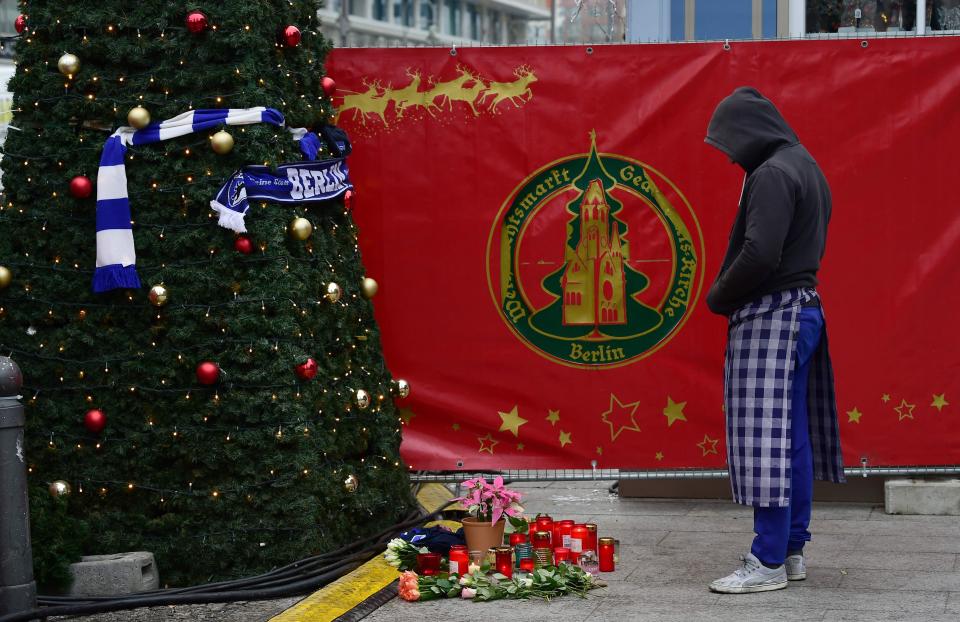  Mourners pay their respects at the scene of Amri's massacre