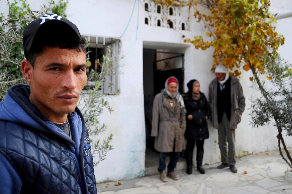  Brother Walid Amri poses for a photo in front of the family house where Anis Amri used to live