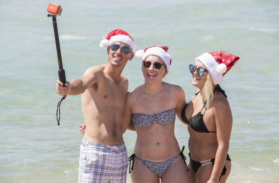  Three Christmas chums pose in the water for a Christmas selfie