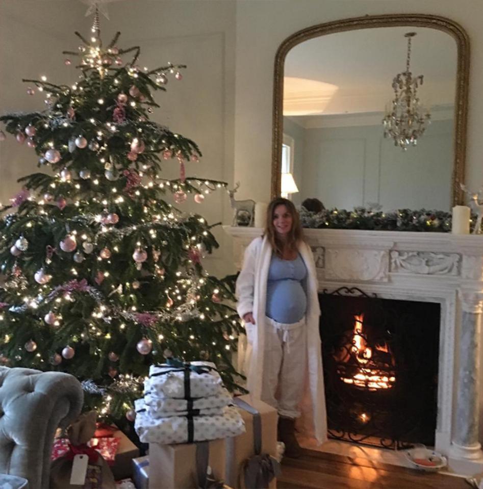  Geri Horner proudly shows off her bump by the fireplace