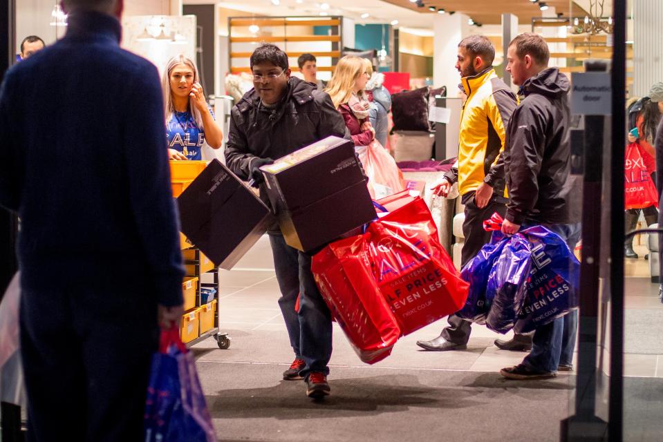  One of an estimated 800 early morning shoppers leaves NEXT with several bags of goods