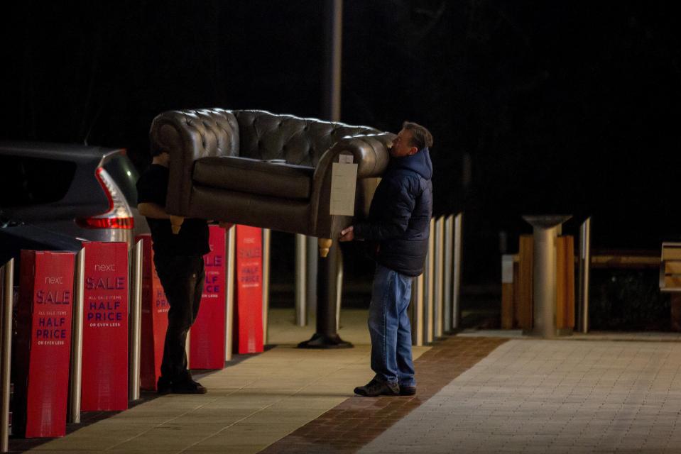  A man leaves a NEXT store in Cheltenham carrying a sofa