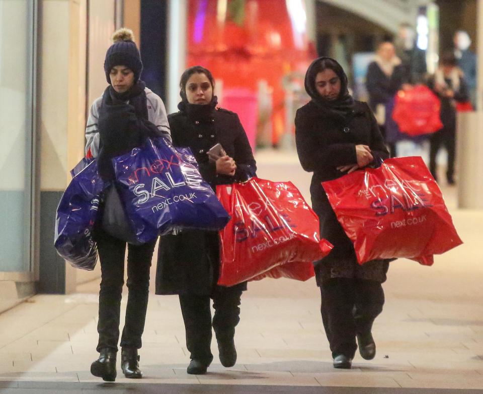  Shoppers walk through central Leeds carrying bags of goods