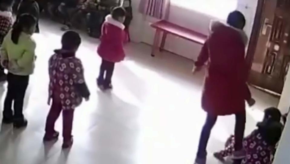  One little girl cowers on the ground as the adult bully boots her