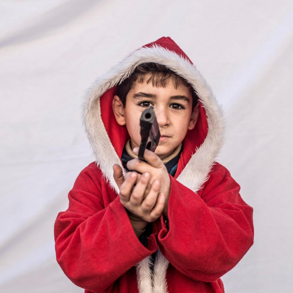  Kayaks, 7, poses for a picture holding toy gun in a camp where Christians displaced by ISIS militants are living in Irbil, Iraq