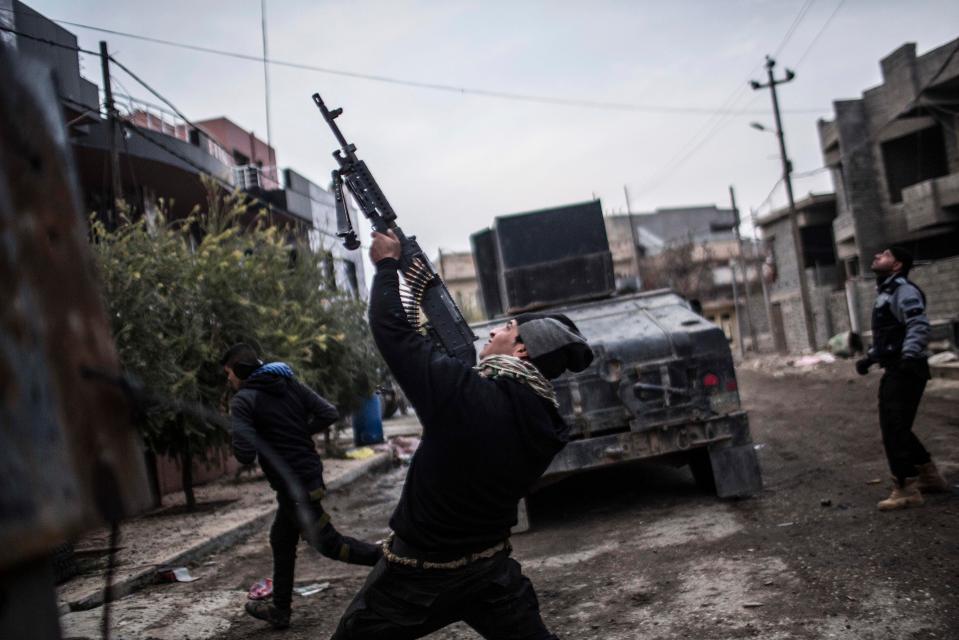  A member of the Iraqi Special Forces shoots his machine gun while fighting ISIS in Mosul