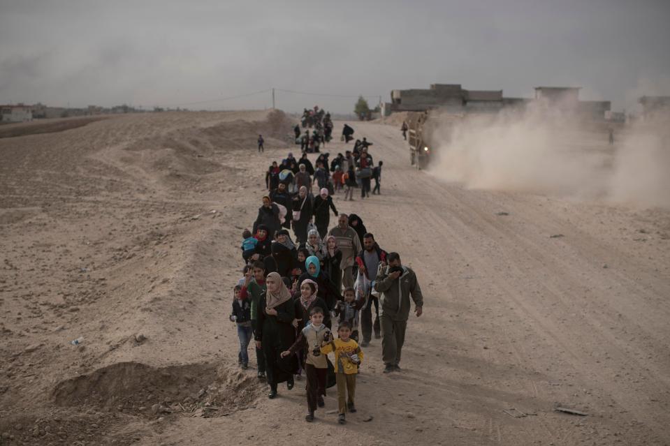  People flee fighting between Iraqi forces and ISIS fighters on a road in eastern Mosul