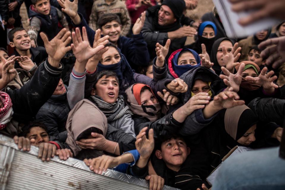  Children beg for food during an aid distribution in Khazer camp for the displaced in Iraqi Kurdistan