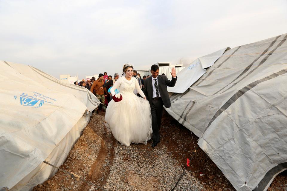  Groom Jassim Mohammed walks with his bride, Amena Ali, during their wedding ceremony at a camp for internally displaced people in Khazir, near Mosul