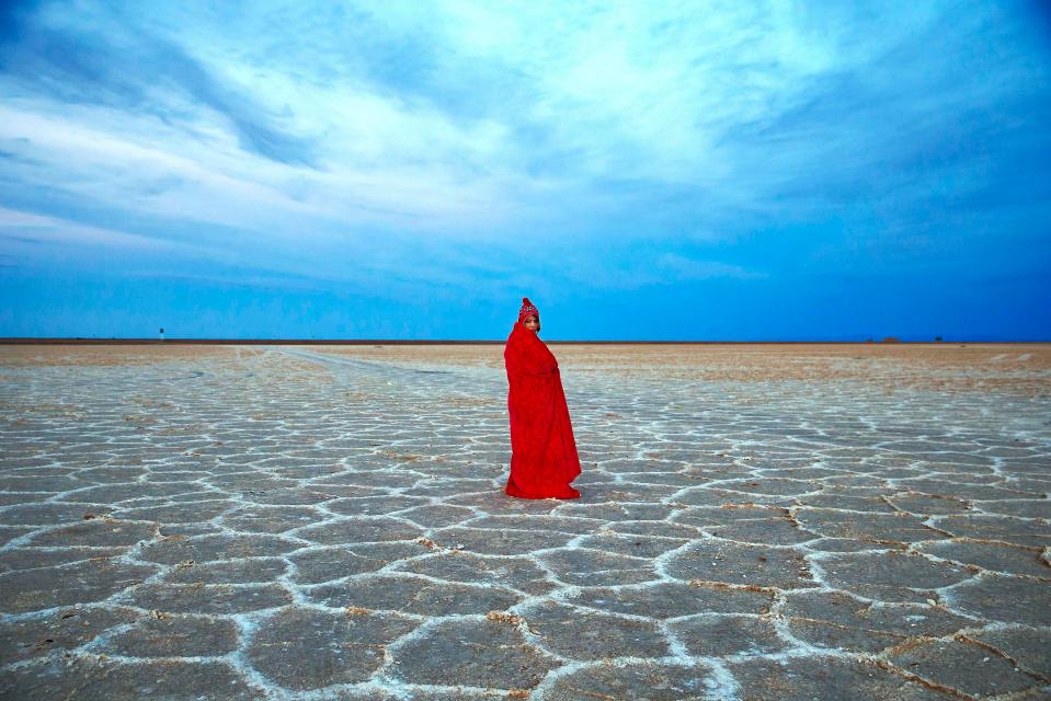  A woman covers herself with a blanket while visiting Khour salt lake in the Mesr desert about 305 miles southeast of Tehran, Iran