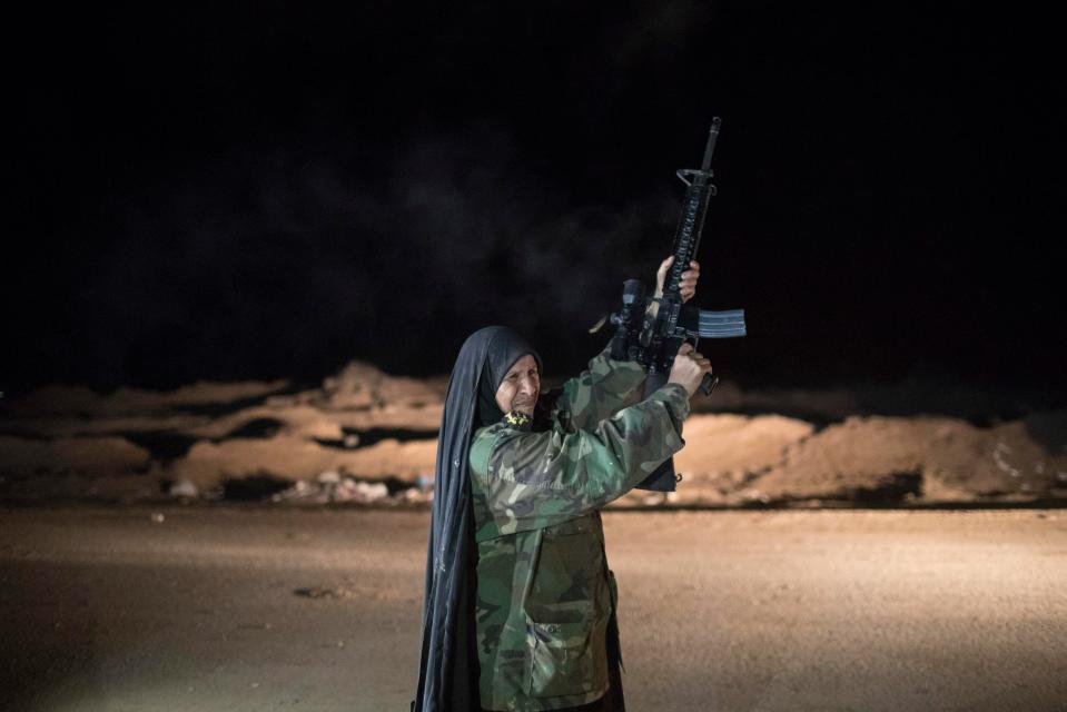  An elderly woman fires into the air at a military base south of Mosul in Iraq