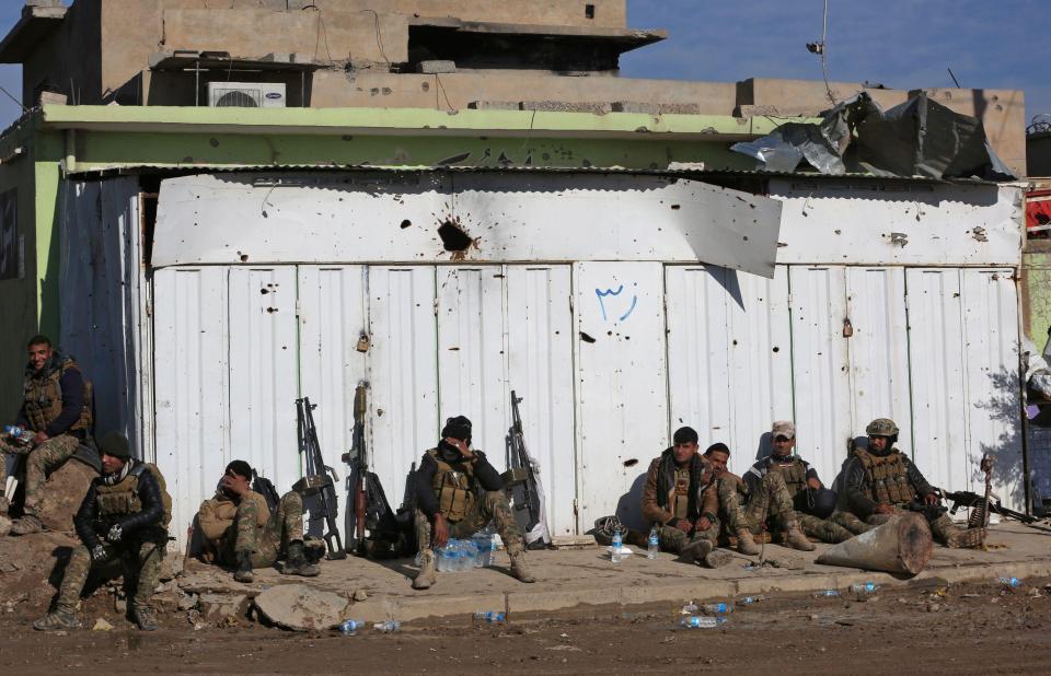  Iraqi pro-government forces take a break as they advance in Mosul's southeastern Sumer neighbourhood on Thursday