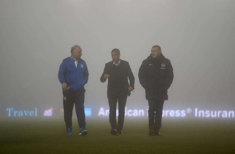  Chris Hughton and his coaching staff inspect the pitch