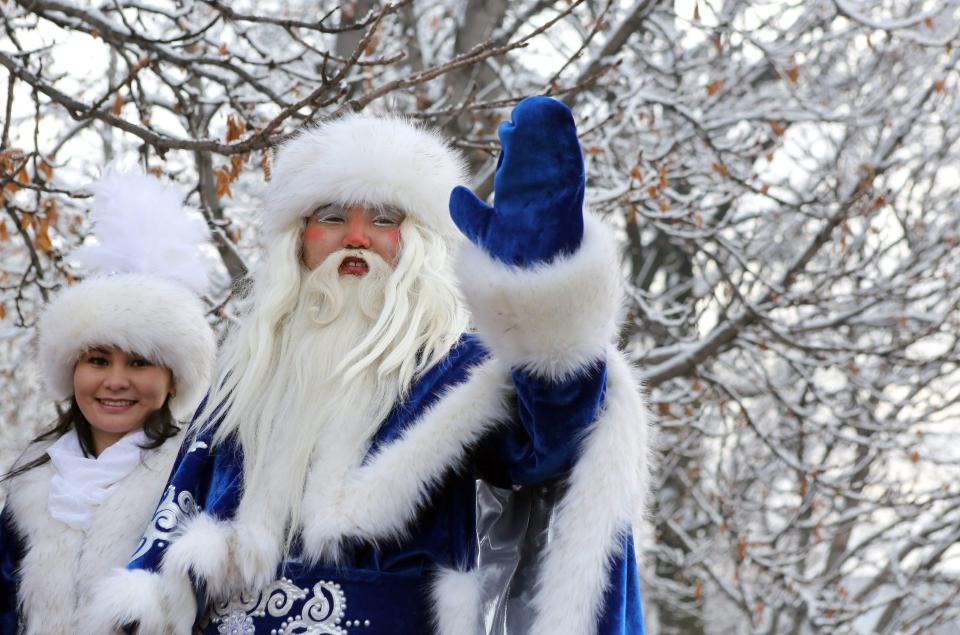  A man and a woman dressed as Father Frost and his granddaughter take part in a New Year's Eve celebration in Bishkek, Kyrgyzstan