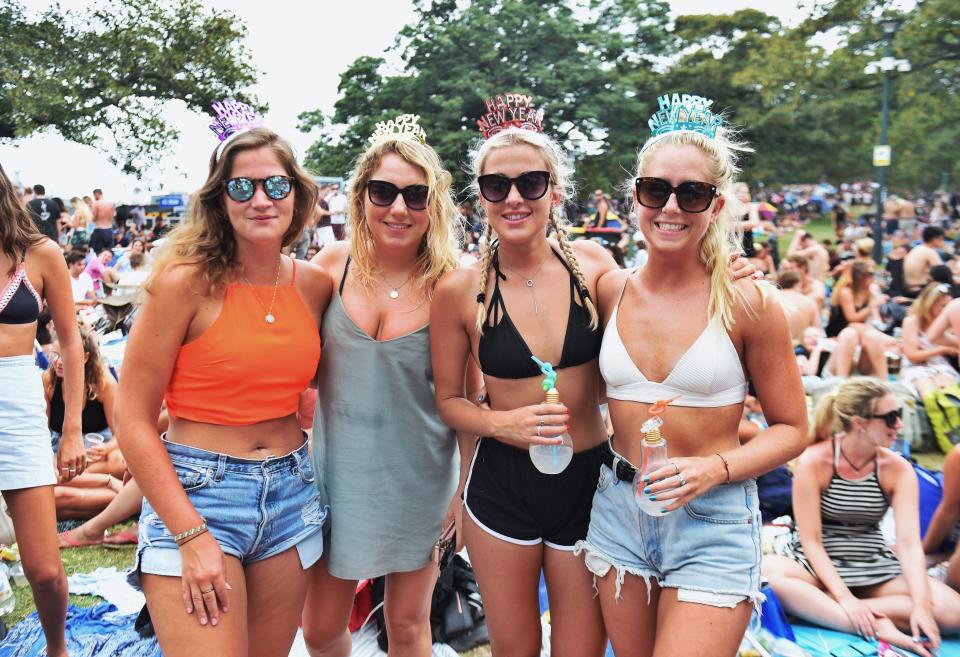  Tourists pose at Mrs Macquarie's Chair on the foreshore of Sydney Harbour waiting for the New Years Eve fireworks