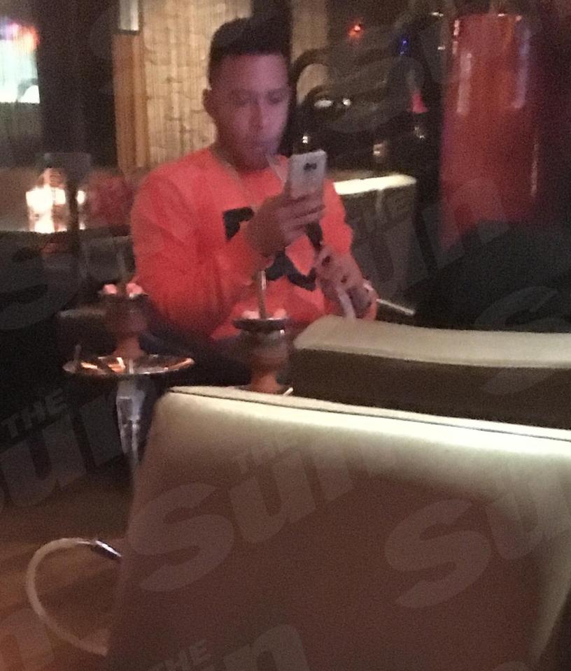  Memphis Depay checks his phone as he takes a puff on the shisha pipe