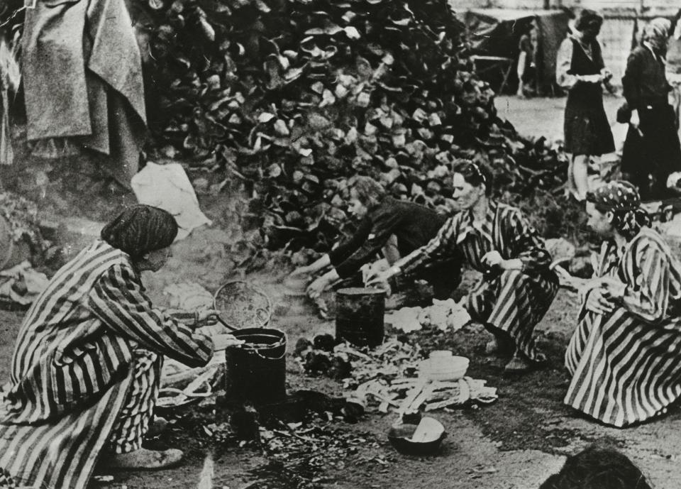  Women collect the dead's boots from a huge pile of bodies at Belsen concentration camp