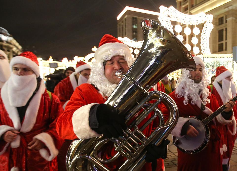  n orchestra of Father Frosts perform at the Journey to Christmas winter festival in Manege Square, Moscow