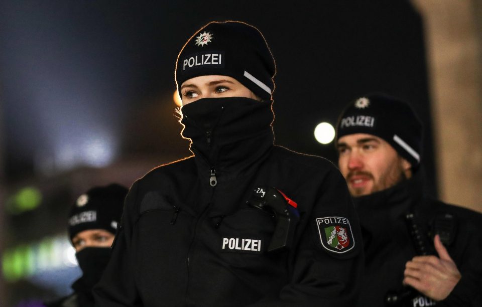  A policewoman wraps up warm as officers watch Hauptbahnhof main railway station in Cologne