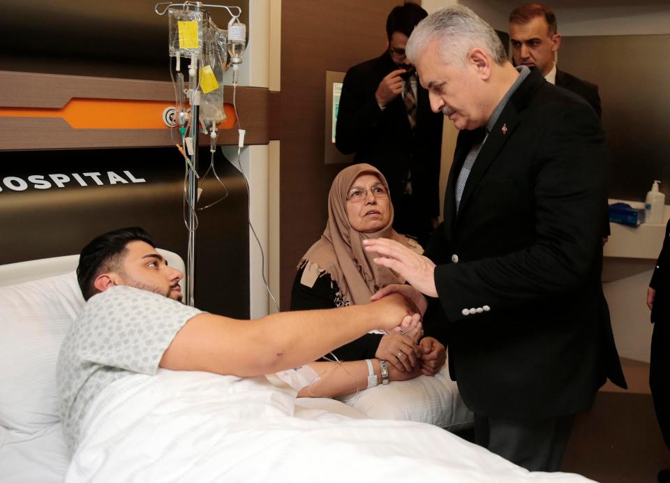  Turkey's Prime Minister Binali Yildirim, right, speaks with a victim in hospital