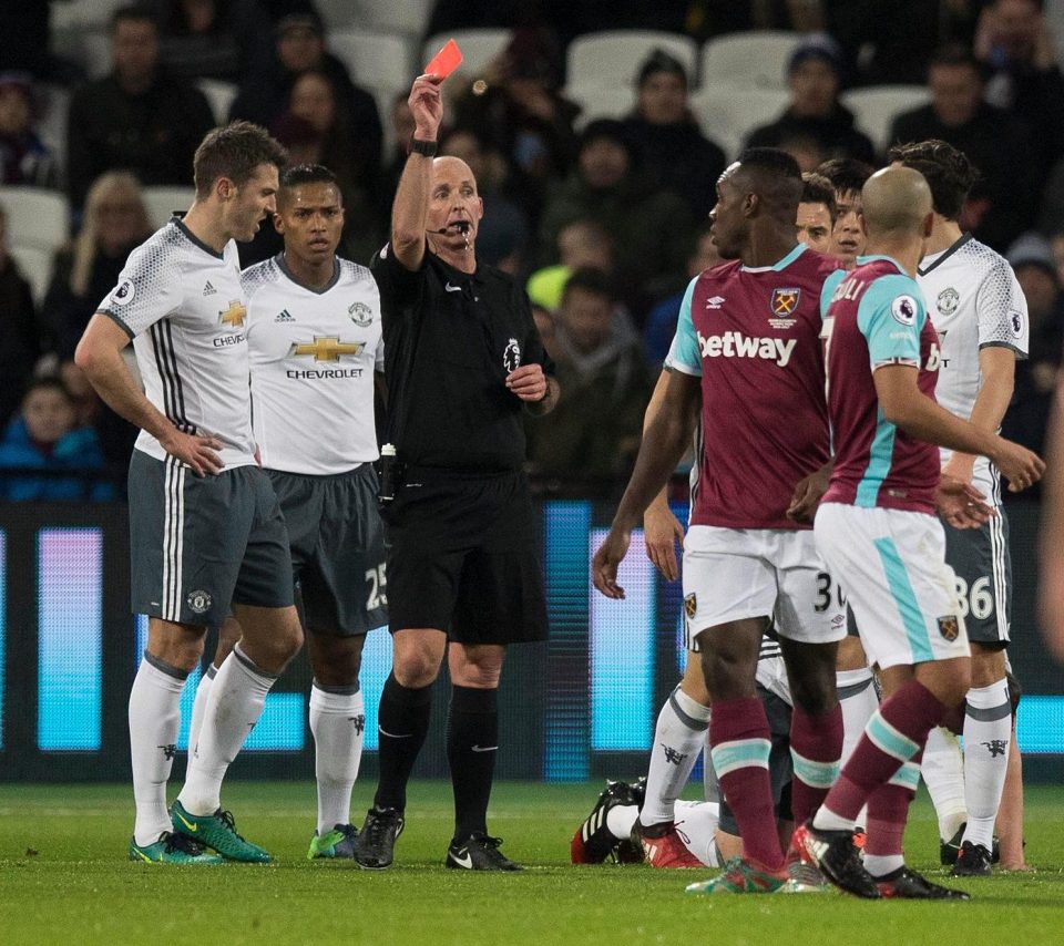  Mike Dean sends off Sofiane Feghouli for his challenge on Phil Jones