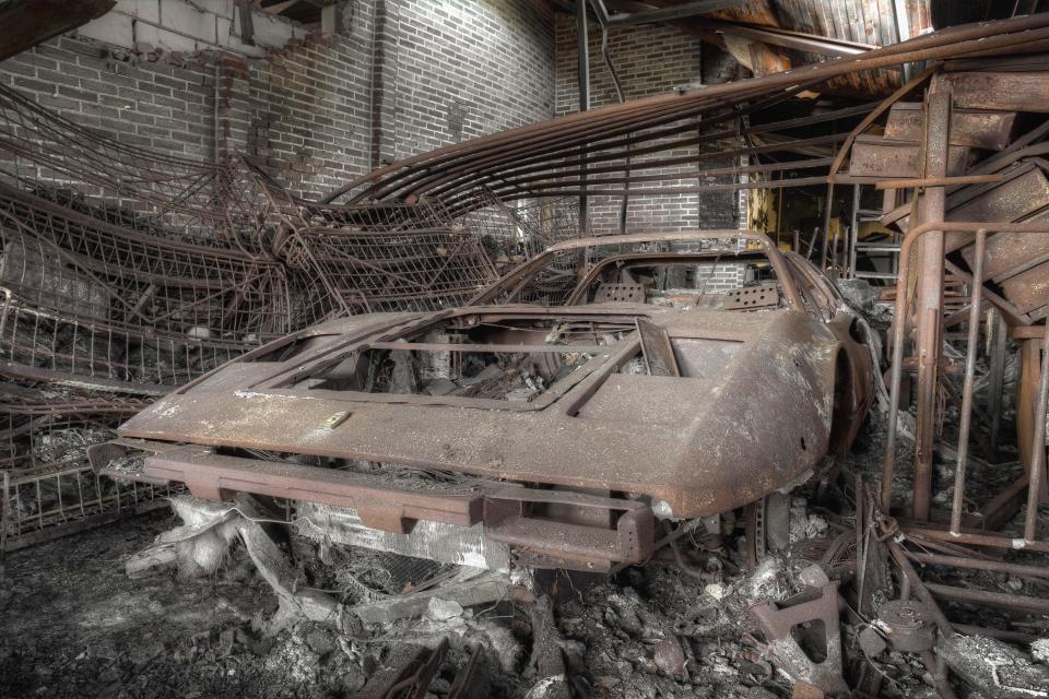  The shell of a Ferrari lies forgotten and surrounded by scrap metal in the this rust-ravaged workshop