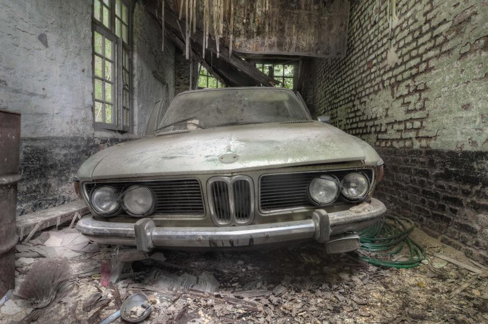  A rusty and deserted BMW, minus the badge, looks almost cartoon-like in this dust-covered garage