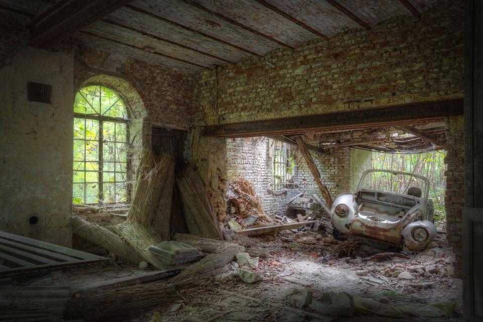  A VW Beetle appears to have smashed through the wall of an abandoned house in this artistic image