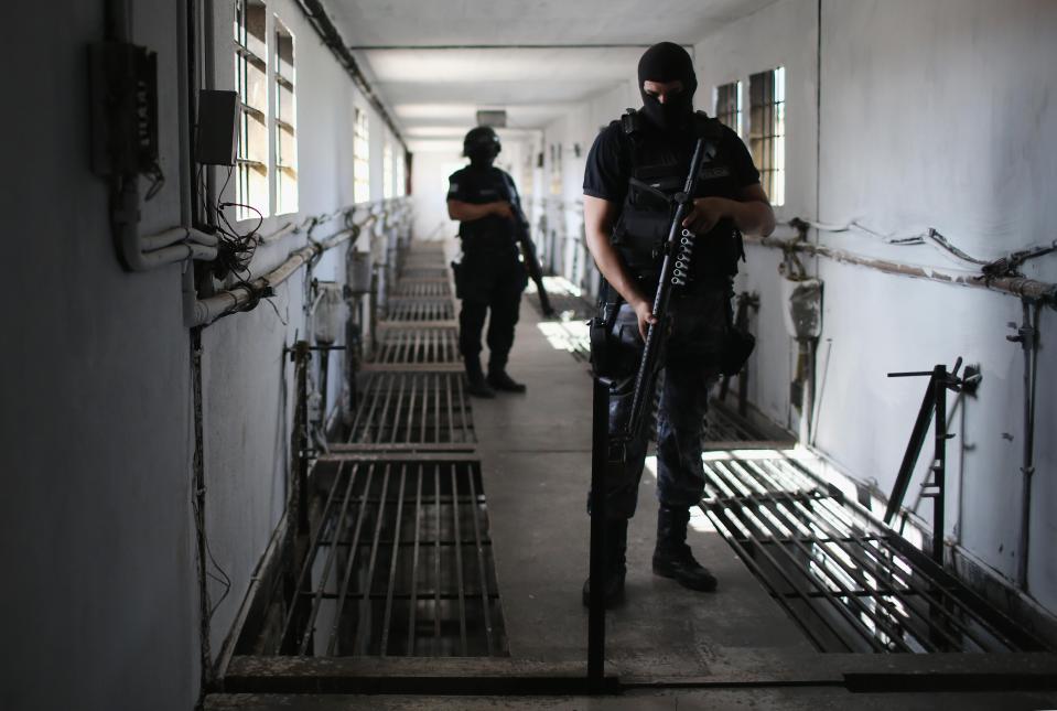  Armed police stalk the hallways of the prison in an effort to quell unrest