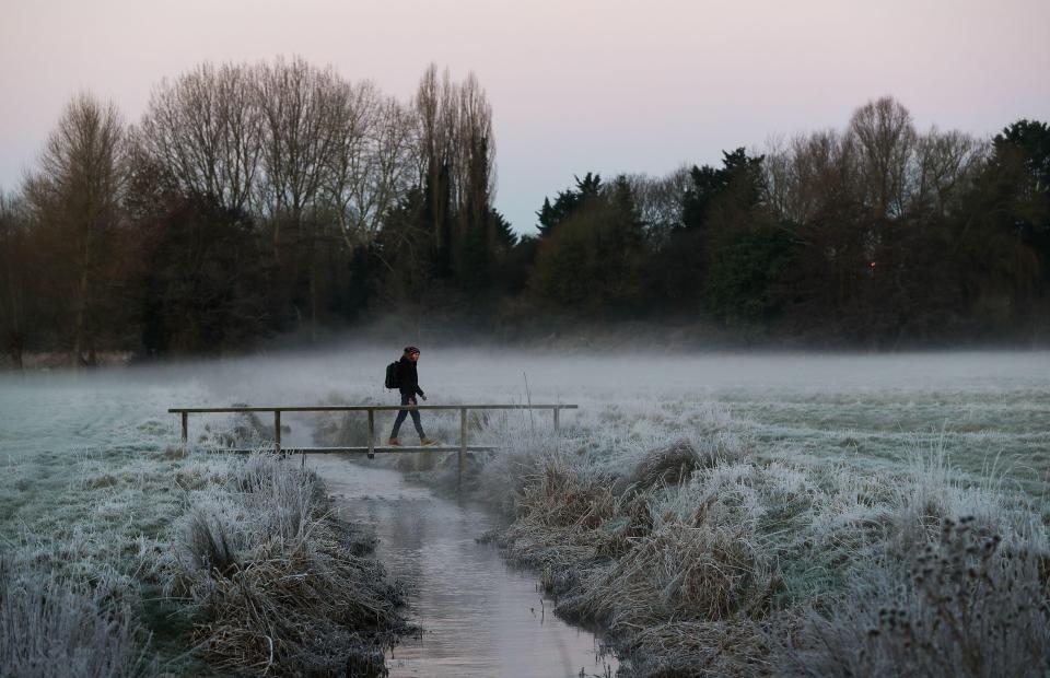  A walker braves the cold in Harnam Water Meadows in Wiltshire this morning after a cold night in the UK