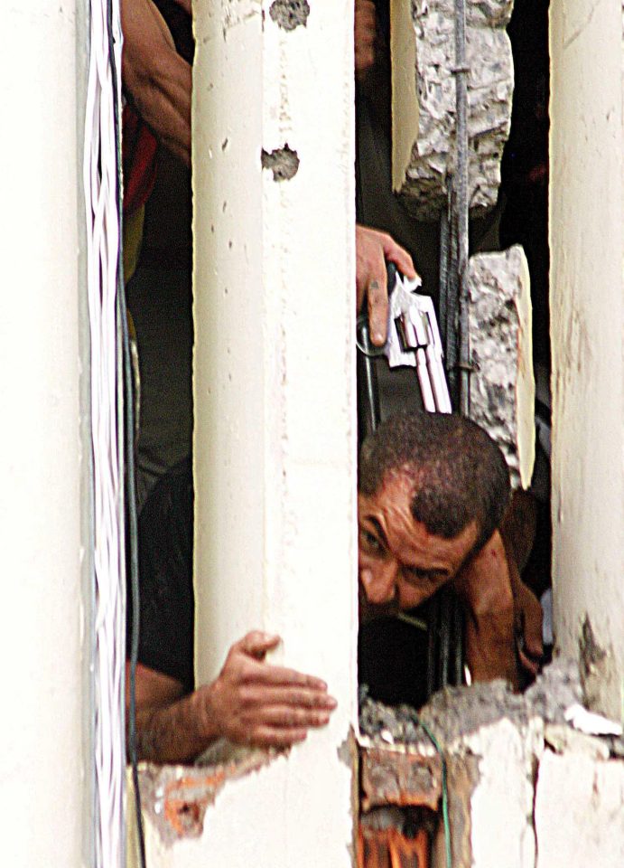  A prisoner points his gun to the head of an unidentified guard during riots at the Laudemir Neves jail in 2006