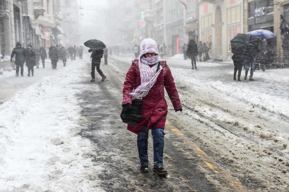  A woman walks along a snow swept road in Istanbul yesterday as the cold continues