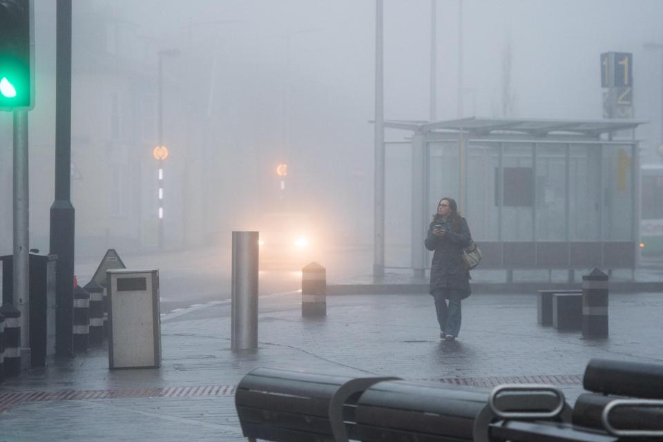  A commuter battles thick fog in Aberystwyth, Wales, this morning