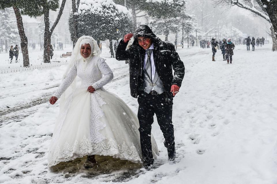  A newly married couple walk through Sultanahmet square during heavy snowfall in Istanbul