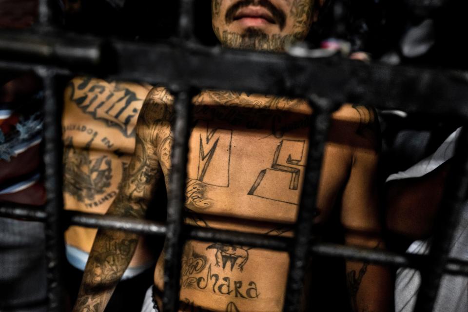  A MS-13 member stands behind bars in a cell at a detention centre in San Salvador