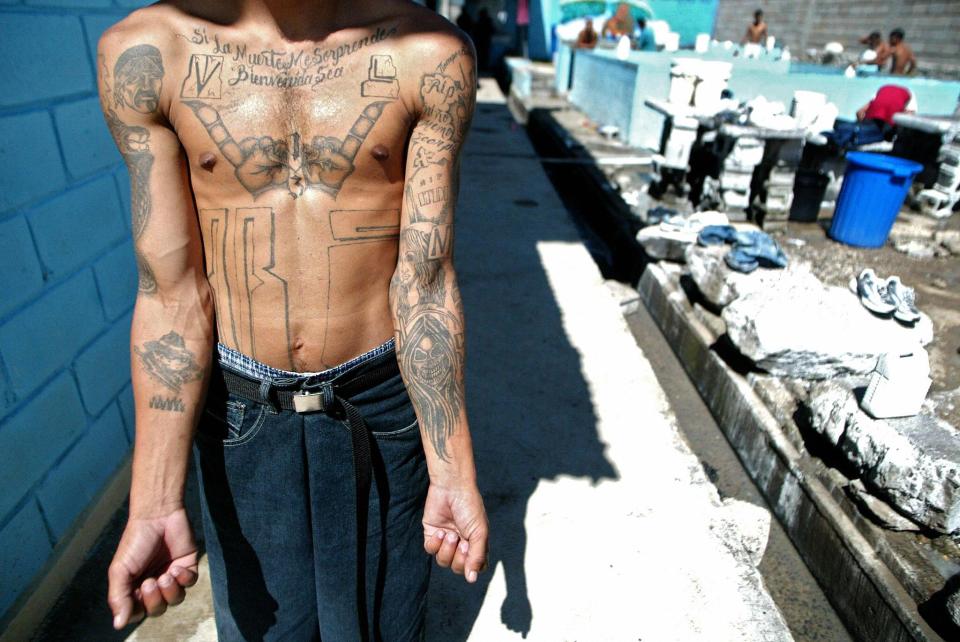  An unidentified member shows his tattoos in the unit where he is kept imprisoned