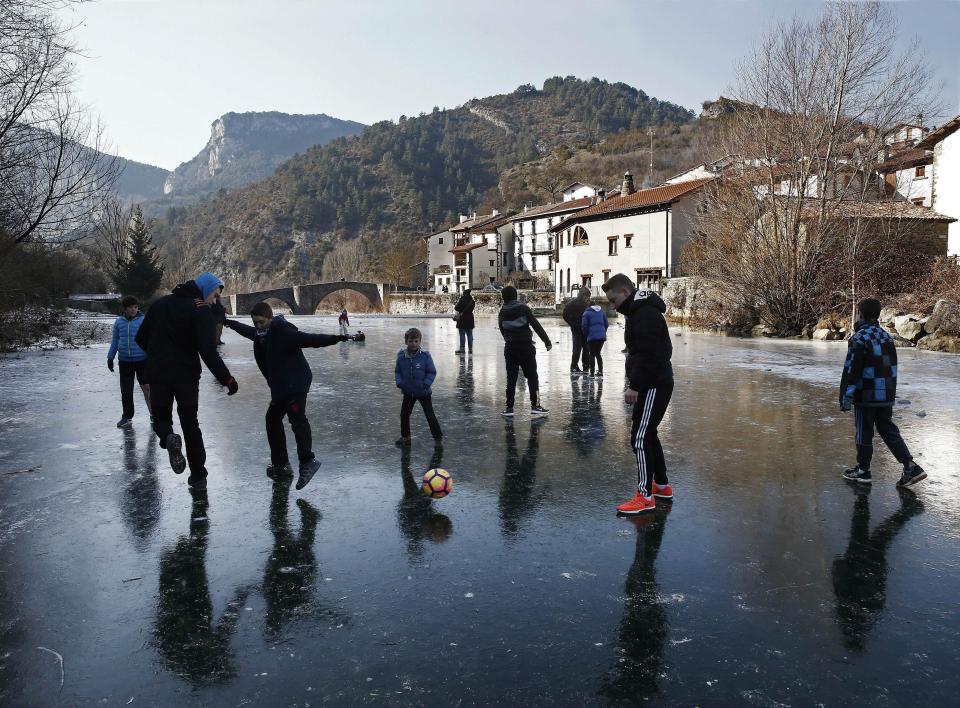  Children play football on the frozen Esca river in the town of Burgui, Navarra in northern Spain