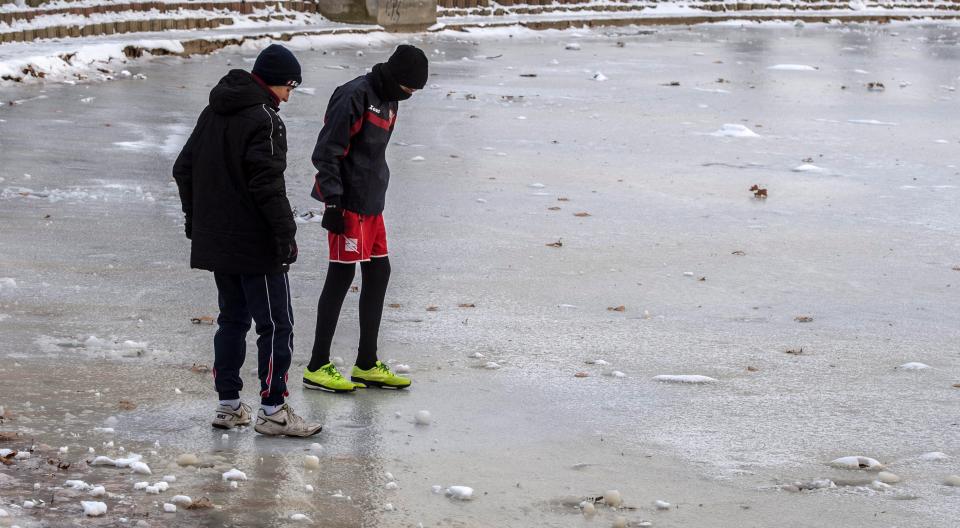  Two boys cautiously test a frozen lake in the city of Skopje, Macedonia