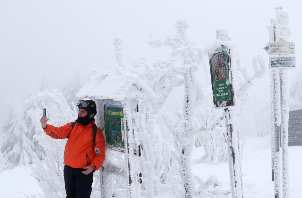  A man takes the opportunity for a snowy selfie beside a sign in the Czech Republic