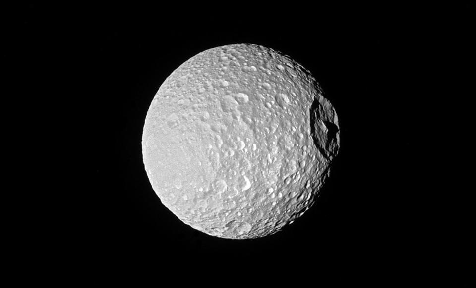  Shadows cast across Saturn moon Mimas' defining feature, Herschel Crater - sometimes referred to as the Death Star moon