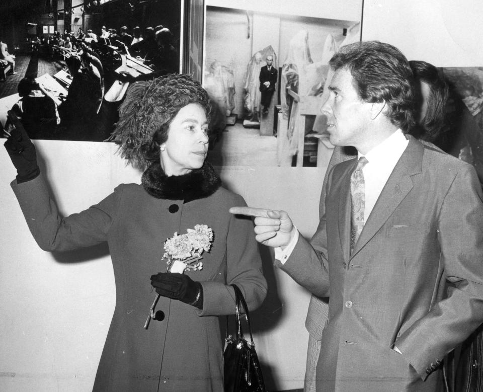  The Queen discusses a photo with Lord Snowdon at Olympia, West London, where his work was on display at the Ideal Home Exhibition