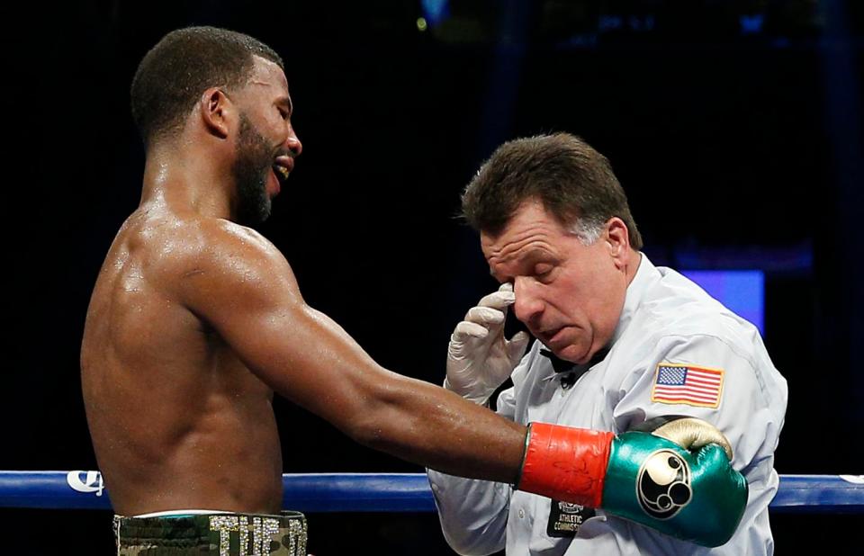  Badou Jack pauses to check on the bruised ref after accidentally almost flooring him