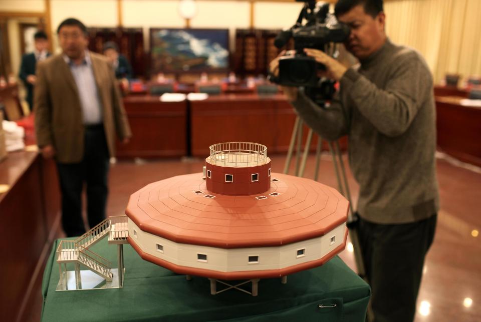  . A cameraman shoots the model of the Taishan Station during its launching ceremony in Beijing