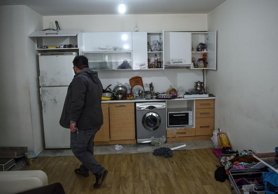  A man walks through the kitchen where four people were arrested